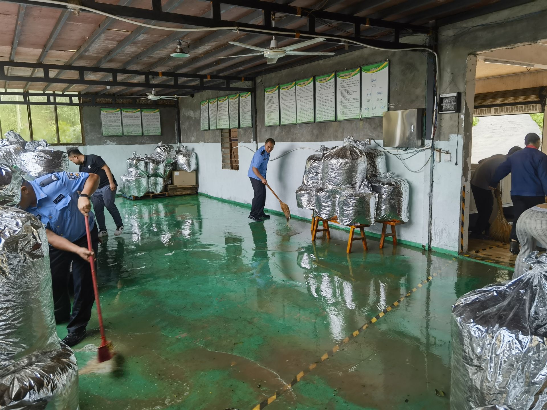环食药侦大队帮助商家搬运茶叶、排除积水.jpg