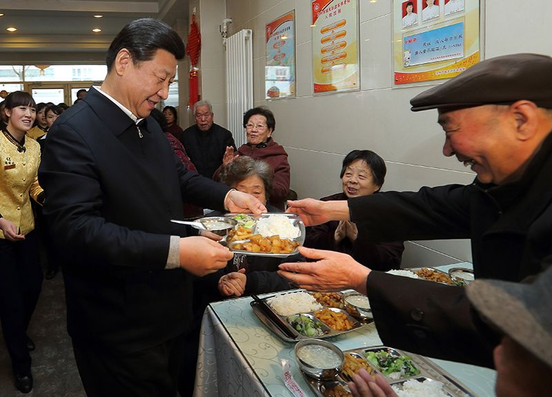 2013年2月4日,习近平总书记来到甘肃兰州一家养老餐厅,端起一盘热气腾腾的饭菜,送到一位老人面前。
