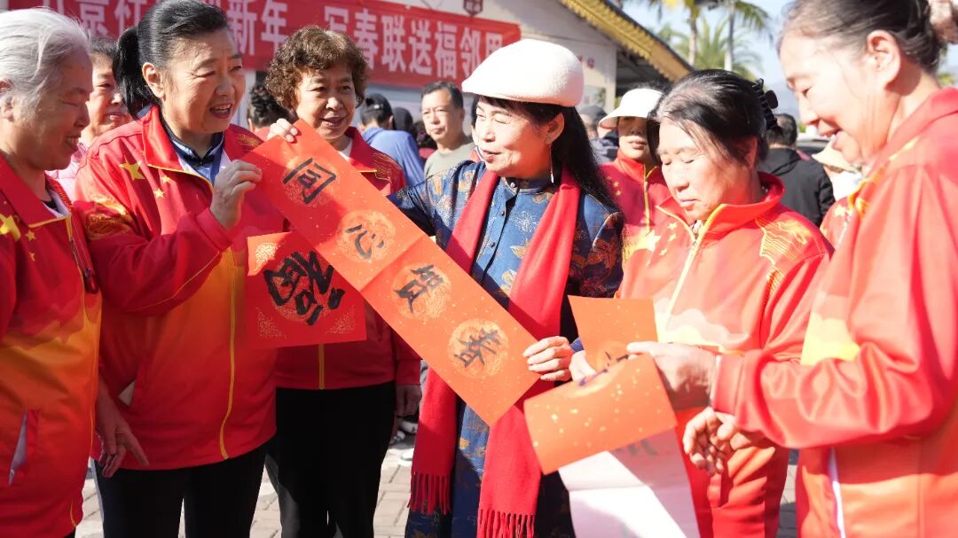 张显荣(右三)在和旅居好友分享自己写的春联 廖显春摄 (2).jpg